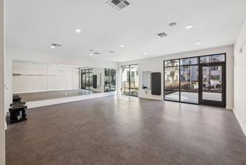 a large empty room with glass doors and white walls at Link Apartments® Broad Ave, Tennessee